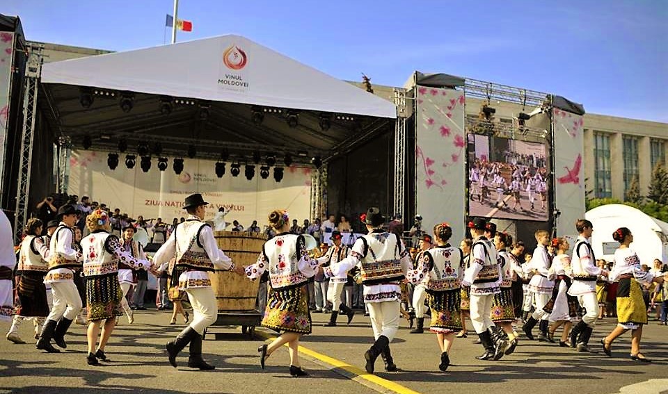 Suasana perayaan wine di Moldova dengan deretan stan produsen dan pengunjung yang mencicipi wine pada sebuah festival terbuka.