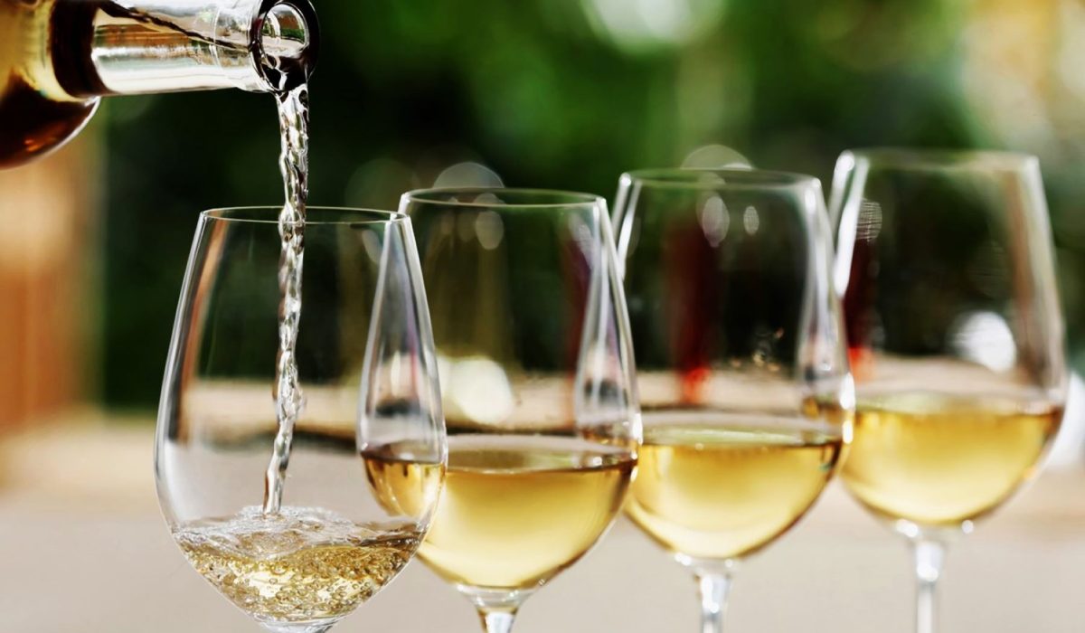 A glass of chilled white wine being poured and served at the ideal serving temperature.