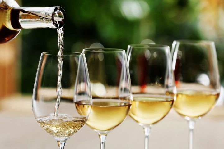 A glass of chilled white wine being poured and served at the ideal serving temperature.