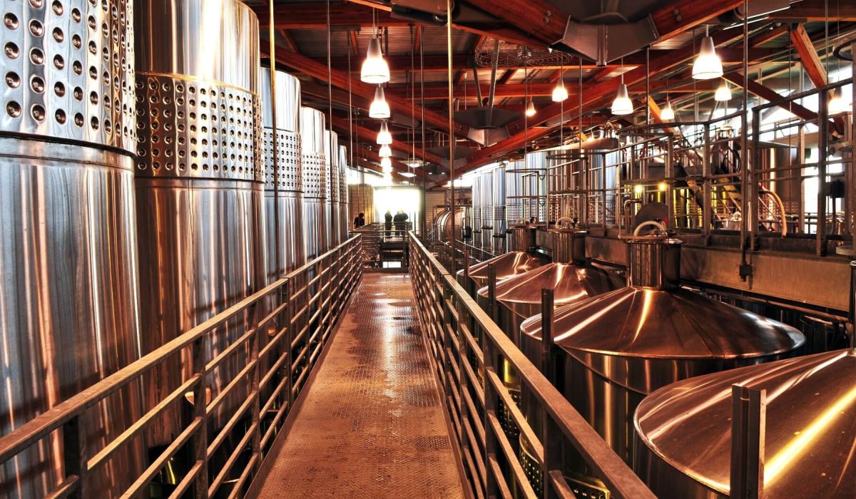 How Wine Is Made: From Grape to Bottle 1 Stainless steel fermentation tanks inside a modern winery show how wine is made, from grape to bottle.