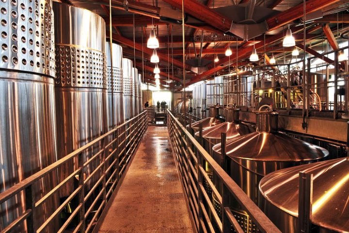 How Wine Is Made: From Grape to Bottle 15 Stainless steel fermentation tanks inside a modern winery show how wine is made, from grape to bottle.