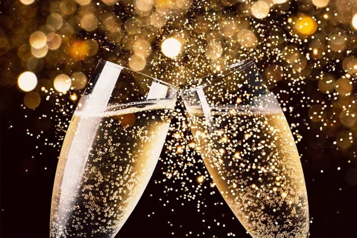Memilih Wine untuk Perayaan: Sparkling, White, dan Red Sesuai Momen 7 Gelas-gelas sparkling wine diangkat dan dibenturkan untuk bersulang dalam sebuah perayaan.