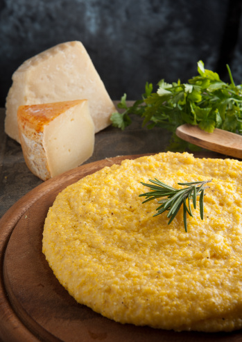 A plate of golden mămăligă, the traditional Moldovan cornmeal dish served with cheese, sour cream and hearty sides.