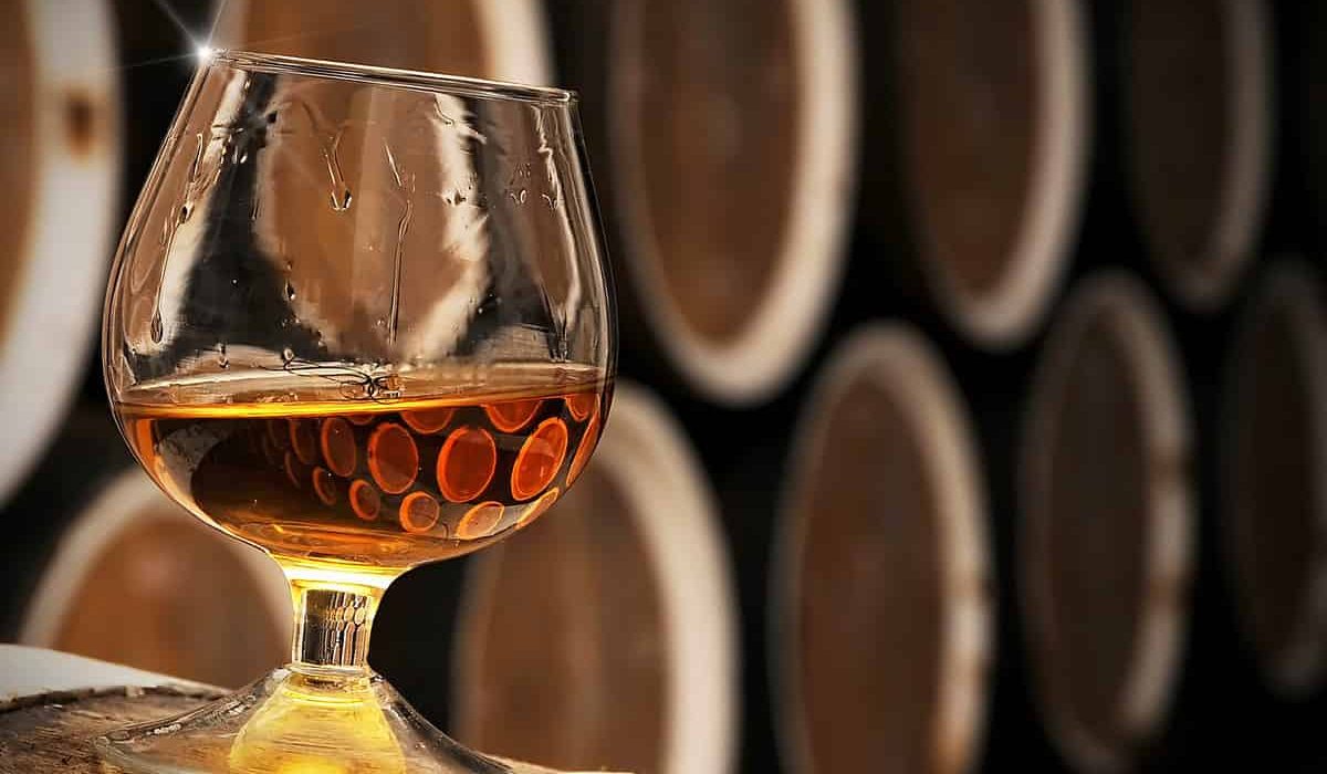A glass of Divin, Moldova's oak-aged protected brandy, swirled beside oak barrels.